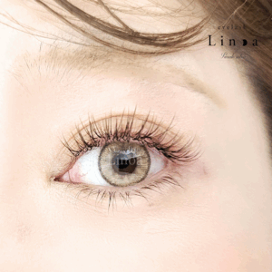 アップワードラッシュ仕上げのフラットラッシュ×ボリュームラッシュMIXデザイン。長さMIXで程よい束感と立体感を出し、ブラウンカラーで柔らかく上品に仕上げた大人マツエク。