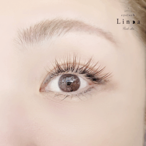 カラーマツエク（ブラウン系）。ボリュームラッシュ×フラットラッシュを組み合わせたブラウンMIXをアップワードラッシュで仕上げた華やかで上品なまつ毛デザイン